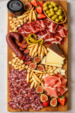 Primavera Charcutería Selection serving suggestion with Ibérico and Serrano ham, chorizo, salchichón, Manchego, olives, almonds and picos; board and fruit not included